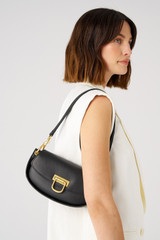 Profile view of model wearing the Oroton Colt Small Baguette in Black and Smooth leather for Women