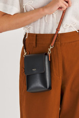 Profile view of model wearing the Oroton Harriet Phone Crossbody in Black and Saffiano Leather for Women