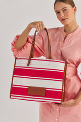 Profile view of model wearing the Oroton Daisy Large Tote in Apple/Cream and Stripe Canvas Fabric and Smooth Leather Trim for Women