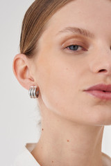 Profile view of model wearing the Oroton Drew Mini Hoops in Silver and Brass Base Metal With Rhodium Plating for Women