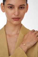 Profile view of model wearing the Oroton Fawne Circle Bracelet in Gold/Clear and Brass Base With 18CT Gold Plating /Cubic Zirconia for Women