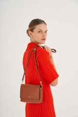 Profile view of model wearing the Oroton Harriet Crossbody in Cognac and Saffiano Leather With Smooth Leather Trim for Women