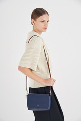 Profile view of model wearing the Oroton Harriet Crossbody in Indigo and Saffiano Leather With Smooth Leather Trim for Women