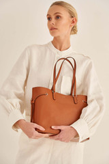 Profile view of model wearing the Oroton Harriet Medium Tote in Cognac and Saffiano Leather With Smooth Leather Trim for Women