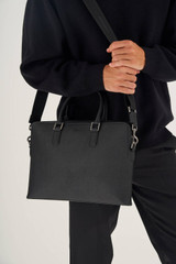 Profile view of model wearing the Oroton Hugo 13" Slim Laptop Bag in Black and Saffiano Leather for Men