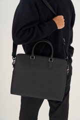 Profile view of model wearing the Oroton Hugo 15" Griptop in Black and Saffiano Leather for Men