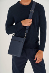 Profile view of model wearing the Oroton Hugo Messenger Bag in Ink and Saffiano Leather for Men