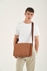 Profile view of model wearing the Oroton Harry Pebble EW Satchel in Cognac and Pebble Leather for Men