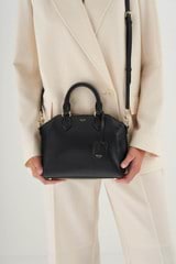 Profile view of model wearing the Oroton Inez Mini Day Bag in Black and Saffiano Leather for Women