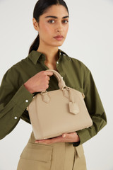 Profile view of model wearing the Oroton Inez Mini Day Bag in Fawn and Saffiano Leather for Women