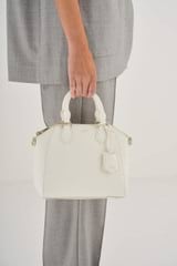 Profile view of model wearing the Oroton Inez Mini Day Bag in Cream and Saffiano Leather for Women