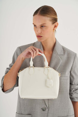 Profile view of model wearing the Oroton Inez Mini Day Bag in Cream and Saffiano Leather for Women
