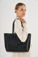 Profile view of model wearing the Oroton Inez Shopper Tote in Black and Shiny Soft Saffiano for Women