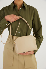Profile view of model wearing the Oroton Inez Slim Crossbody in Fawn and Smooth Saffiano for Women