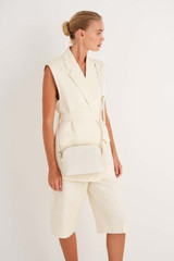 Profile view of model wearing the Oroton Inez Slim Crossbody in Cream and Saffiano Leather for Women