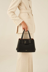 Profile view of model wearing the Oroton Avery Small Three Pocket Day Bag in Black and Soft Pebble Leather for Women