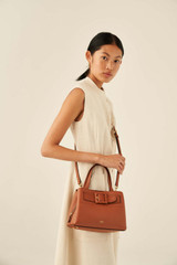 Profile view of model wearing the Oroton Avery Small Three Pocket Day Bag in Toffee and Soft Pebble Leather for Women