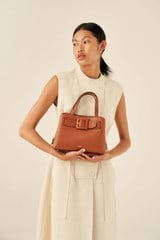 Profile view of model wearing the Oroton Avery Small Three Pocket Day Bag in Toffee and Soft Pebble Leather for Women