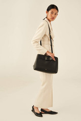 Profile view of model wearing the Oroton Avery Three Pocket Day Bag in Black and Soft Pebble Leather for Women