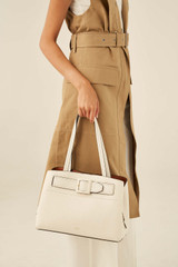 Profile view of model wearing the Oroton Avery Three Pocket Day Bag in Cream and Soft Pebble Leather for Women