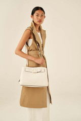 Profile view of model wearing the Oroton Avery Three Pocket Day Bag in Cream and Soft Pebble Leather for Women