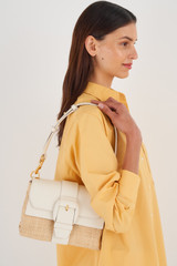 Profile view of model wearing the Oroton Frida Collectable Medium Satchel in Nat/Paper White and Woven Straw and Smooth Leather for Women
