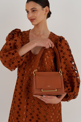 Profile view of model wearing the Oroton Elm Small Day Bag in Brandy and Pebble Leather With Smooth Leather Trim for Women