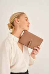 Profile view of model wearing the Oroton Dylan Fold Over Crossbody in Tan and Pebble Leather for Women