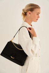 Profile view of model wearing the Oroton Elina Satchel in Black and Pebble Leather for Women