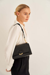Profile view of model wearing the Oroton Elina Small Satchel in Black and Pebble Leather for Women