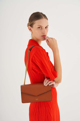 Profile view of model wearing the Oroton Bella Clutch in Cognac and Soft Saffiano for Women