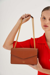 Profile view of model wearing the Oroton Bella Clutch in Cognac and Soft Saffiano for Women