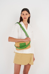 Profile view of model wearing the Oroton Alva Collectable Day Bag in Nat/Grass Green and Smooth Leather and Crocheted Straw for Women