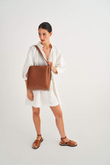 Profile view of model wearing the Oroton Ingrid Hobo in Brandy and Smooth Leather for Women