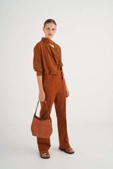 Profile view of model wearing the Oroton Kali Small Hobo in Cognac and Pebble leather for Women