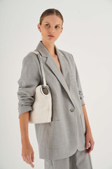 Profile view of model wearing the Oroton Kali Medium Hobo in Cream and Pebble leather for Women