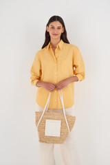 Profile view of model wearing the Oroton Jensen Tote in Nat/Paper White and Smooth Leather and Crocheted Straw for Women