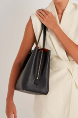 Profile view of model wearing the Oroton Anika 13" Day Bag in Black and Pebble leather for Women
