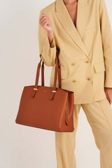 Profile view of model wearing the Oroton Anika 13" Day Bag in Cognac and Pebble leather for Women