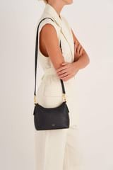 Profile view of model wearing the Oroton Anika Crossbody in Black and Pebble leather for Women
