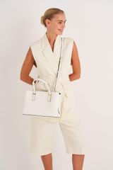Profile view of model wearing the Oroton Anika Small Day Bag in Cream and Pebble leather for Women
