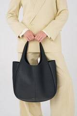 Profile view of model wearing the Oroton Emilia Large Tote in Black and Pebble leather for Women