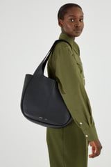 Profile view of model wearing the Oroton Emilia Tote in Black and Pebble leather for Women