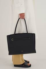Profile view of model wearing the Oroton Audrey Large Tote in Black and Saffiano and Smooth Leather for Women