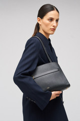 Profile view of model wearing the Oroton Audrey Small Three Pocket Day Bag in Black and Saffiano and Smooth Leather for Women