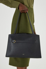 Profile view of model wearing the Oroton Audrey Three Pocket Day Bag in Black and Saffiano and Smooth Leather for Women