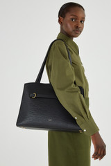 Profile view of model wearing the Oroton Audrey Three Pocket Day Bag in Black and Saffiano and Smooth Leather for Women