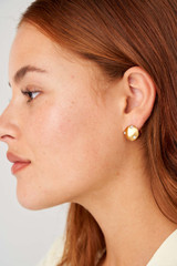 Profile view of model wearing the Oroton Arabella Mini Huggies in Worn Gold and Brass Base With 18CT Gold Plating for Women