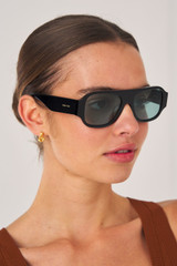 Profile view of model wearing the Oroton Gentry Sunglasses in Black and Acetate for Women