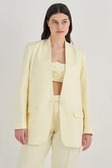 Profile view of model wearing the Oroton Collarless Blazer in Lemon Butter and 58% Viscose, 42% Linen for Women